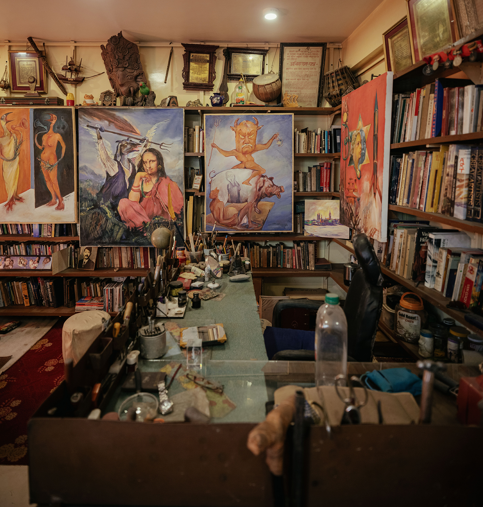 Manuj Babu Mishra&amp;rsquo;s studio, rich with full shelves, paintings, personal items and lots of colourful, lived-in decor