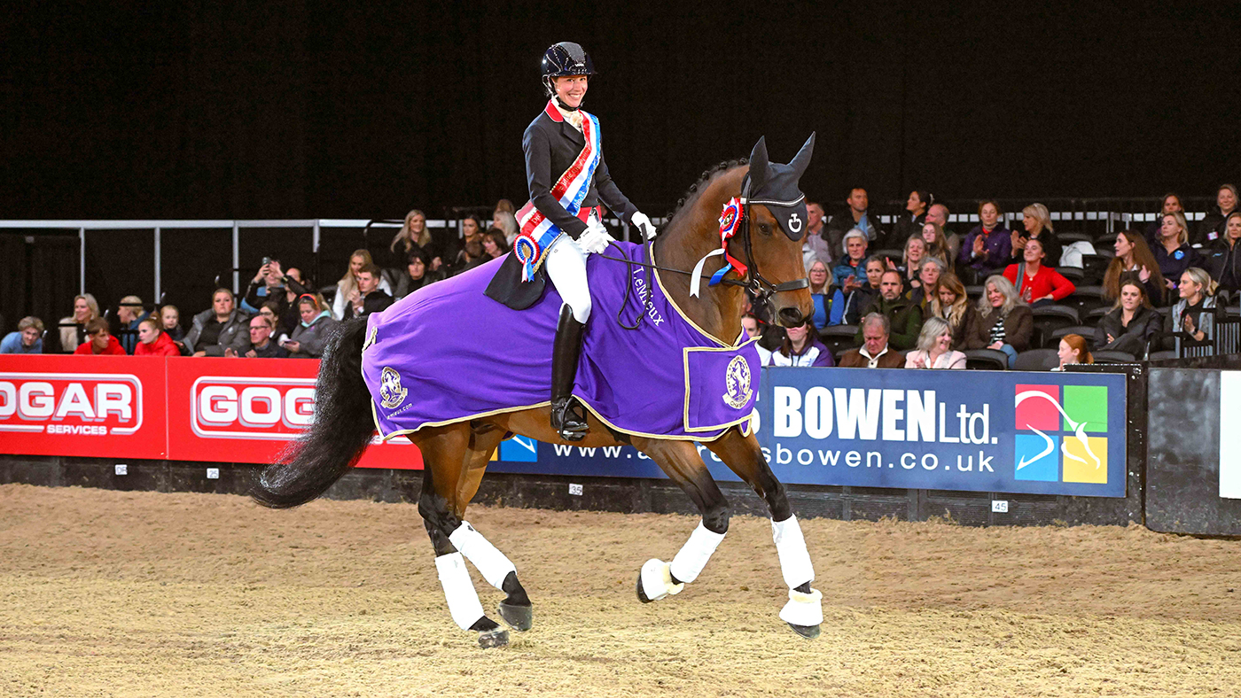 Laura Tomlinson smiles at the camera while on her victory lap on Forest Hill after winning the Dressage Future Elite Championship at HOYS 2024.
