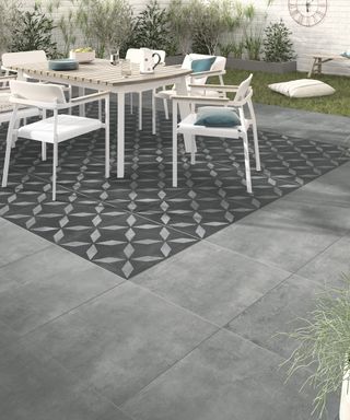 patio with plain and patterned tiles to create an outdoor rug effect