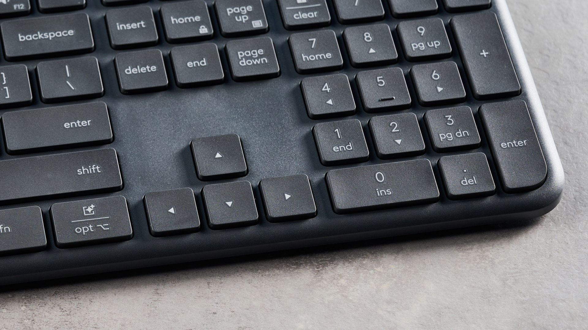 The Logitech K620 keyboard in a graphite grey colorway photographed as part of the MK625 como on able and white background.