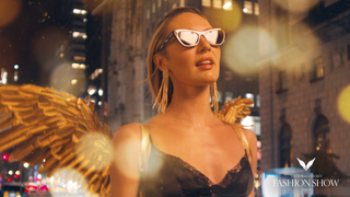 a model walking the Victoria's Secret 2024 fashion show runway in New York City with gold angel wings