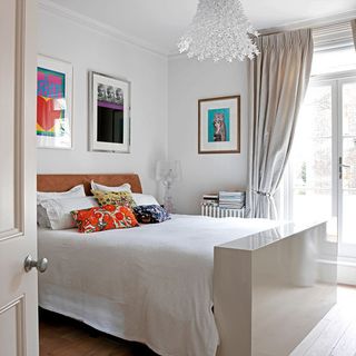 bedroom with bed white wall and wooden flooring