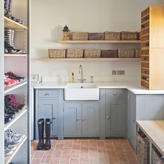 Boot room/utility room with shoe storage, blue cabinets, and a white sink