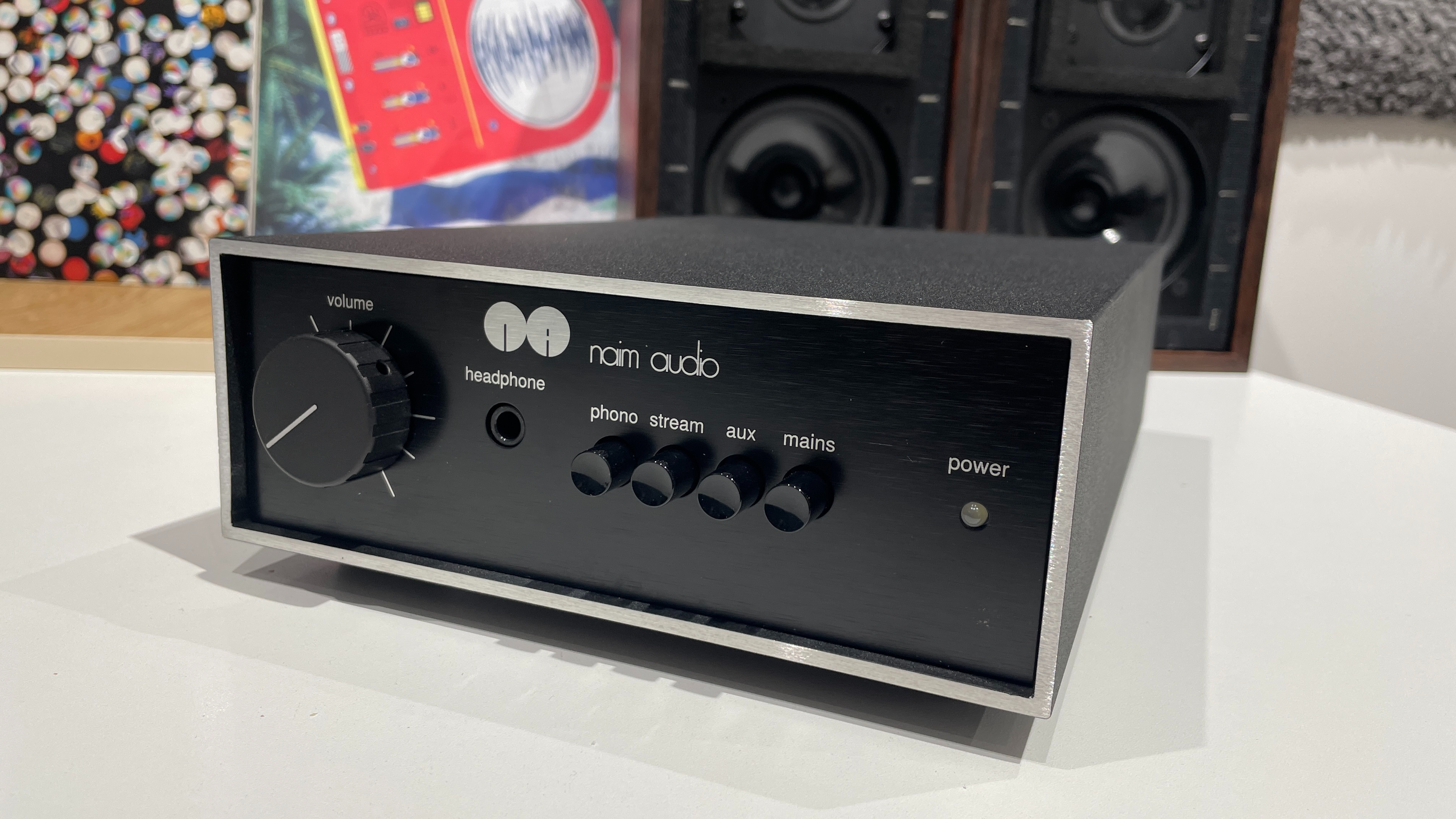 Naim Nait 50 amp on desk with records and speakers in background