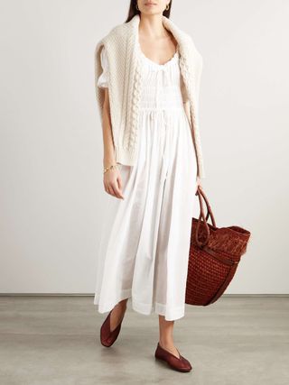 net a porter model wearing white shirred dress and tan flats