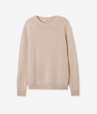 a beige Falconeri cashmere sweater in front of a plain backdrop