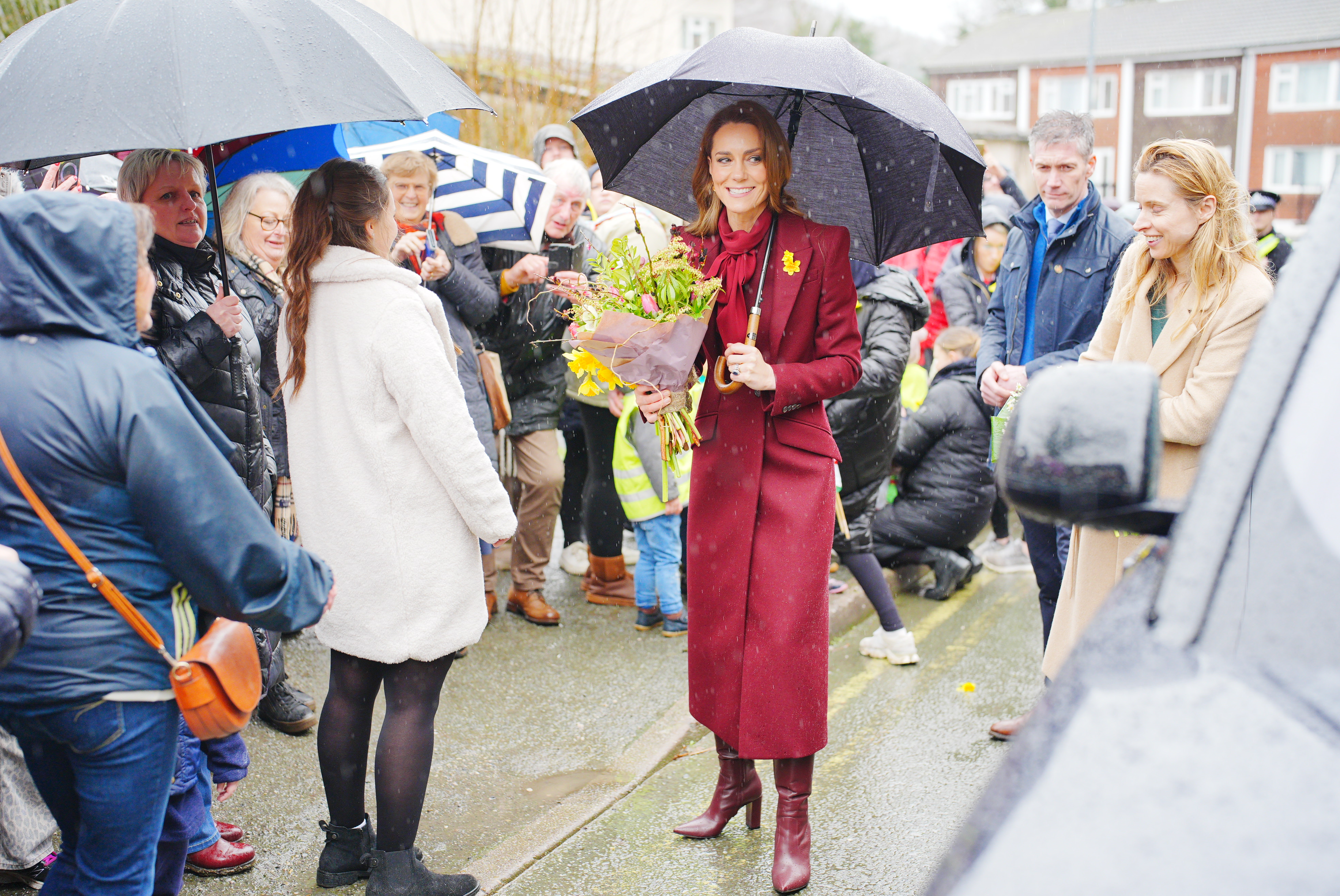 LLANIDLOES, UNITED KINGDOM - FEBRUARY 26: Catherine, Princess of Wales shelters from rain under a umbrella whilst meeting members of the public during a visit to the Hanging Gardens, a space dedicated to nurturing community resilience and creativity, on February 26, 2026 in Llanidloes, Wales. The Prince and Princes of Wales visited communities in Powys, Wales today ahead of St David&amp;amp;apos;s Day. (Photo by Ben Birchall - WPA Pool/Getty Images)