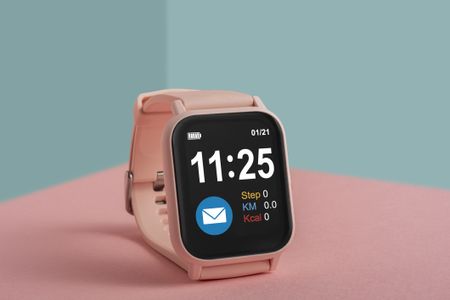 Pink smart watch on a colorful background