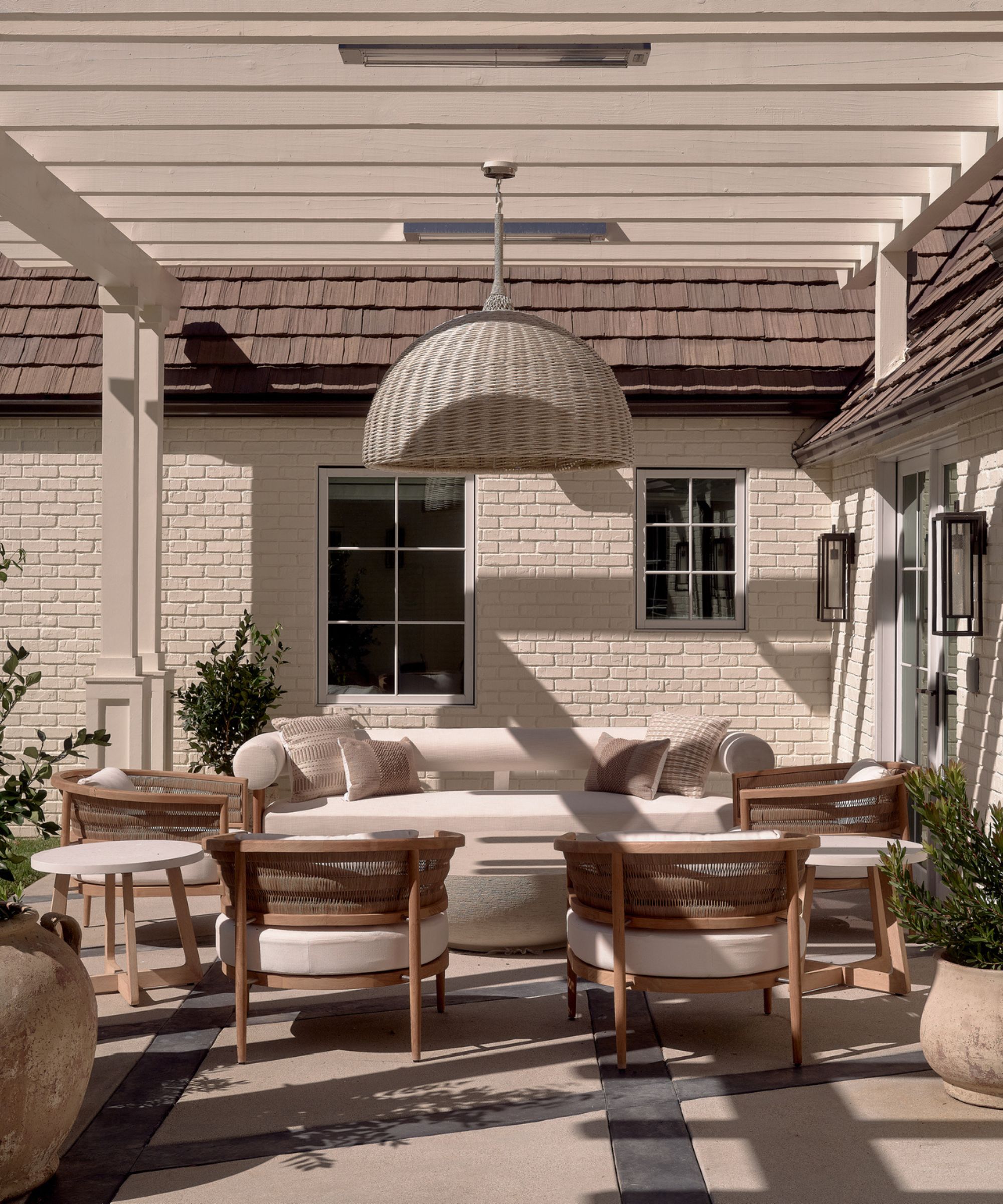 Neutral outdoor living area with pergola and rattan pendant light
