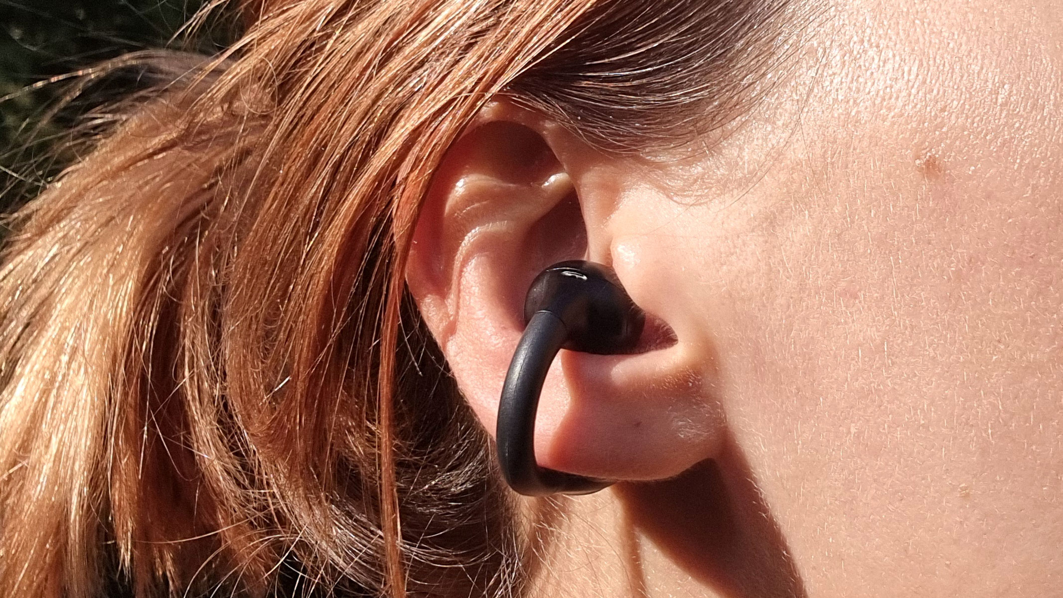 A close-up picture of our reviewer testing the JLab Open Earbuds