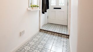 Pale narrow hallway with decorative floor tiles 