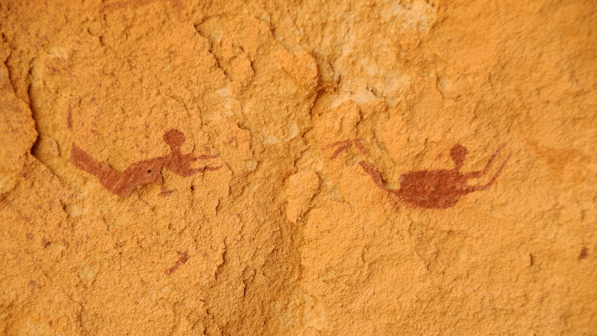 Uma pintura de duas figuras humanas de natação na parede da caverna dos nadadores