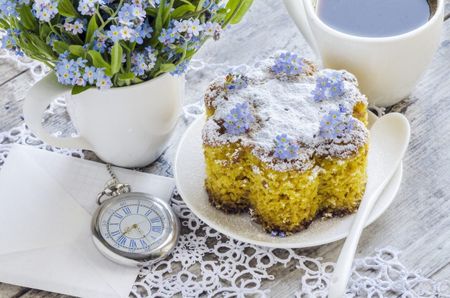 Forget-Me-Not Flowers Next To Small Cake And Tea