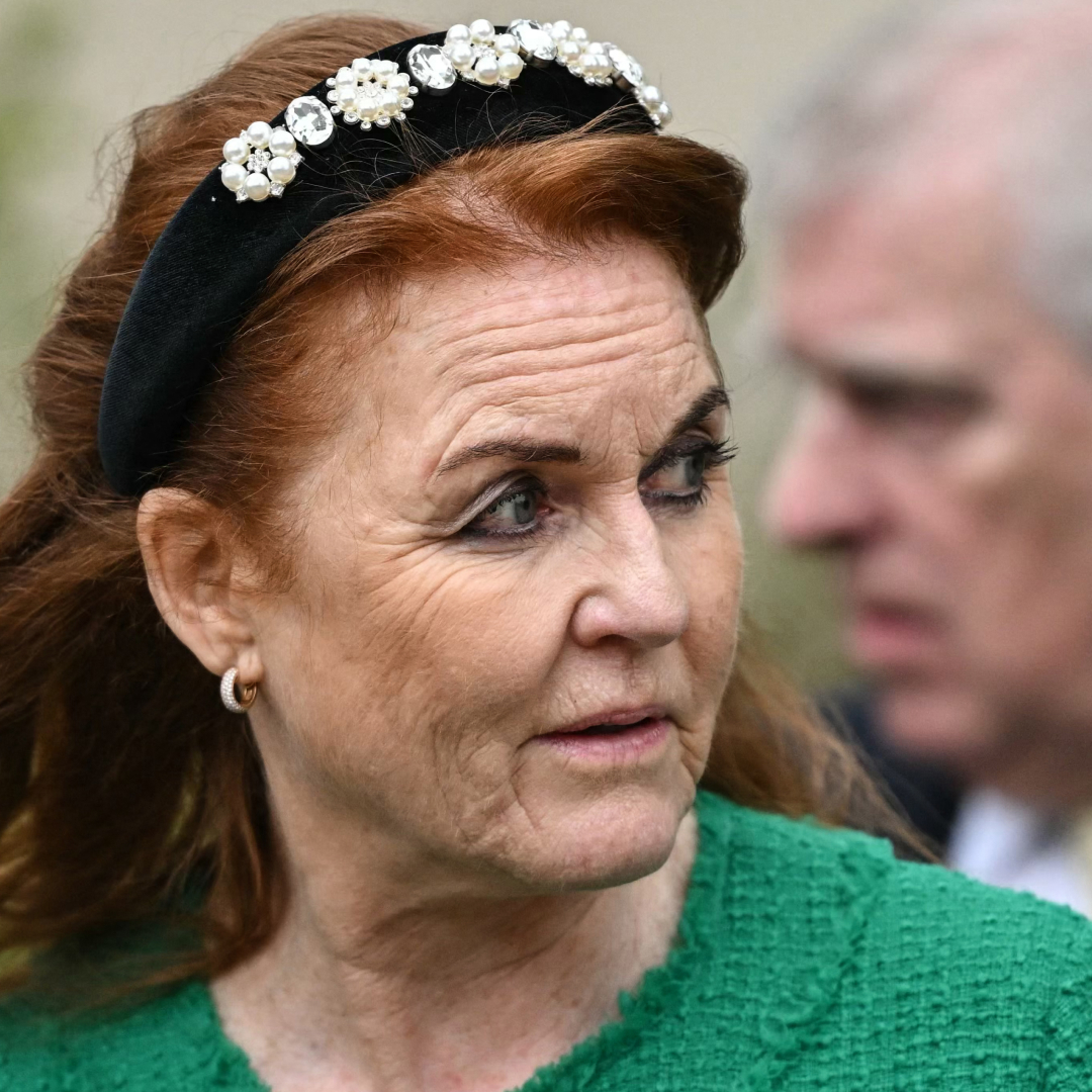 Sarah Ferguson wearing a jeweled headband and green coat looking to the side with Prince Andrew behind her