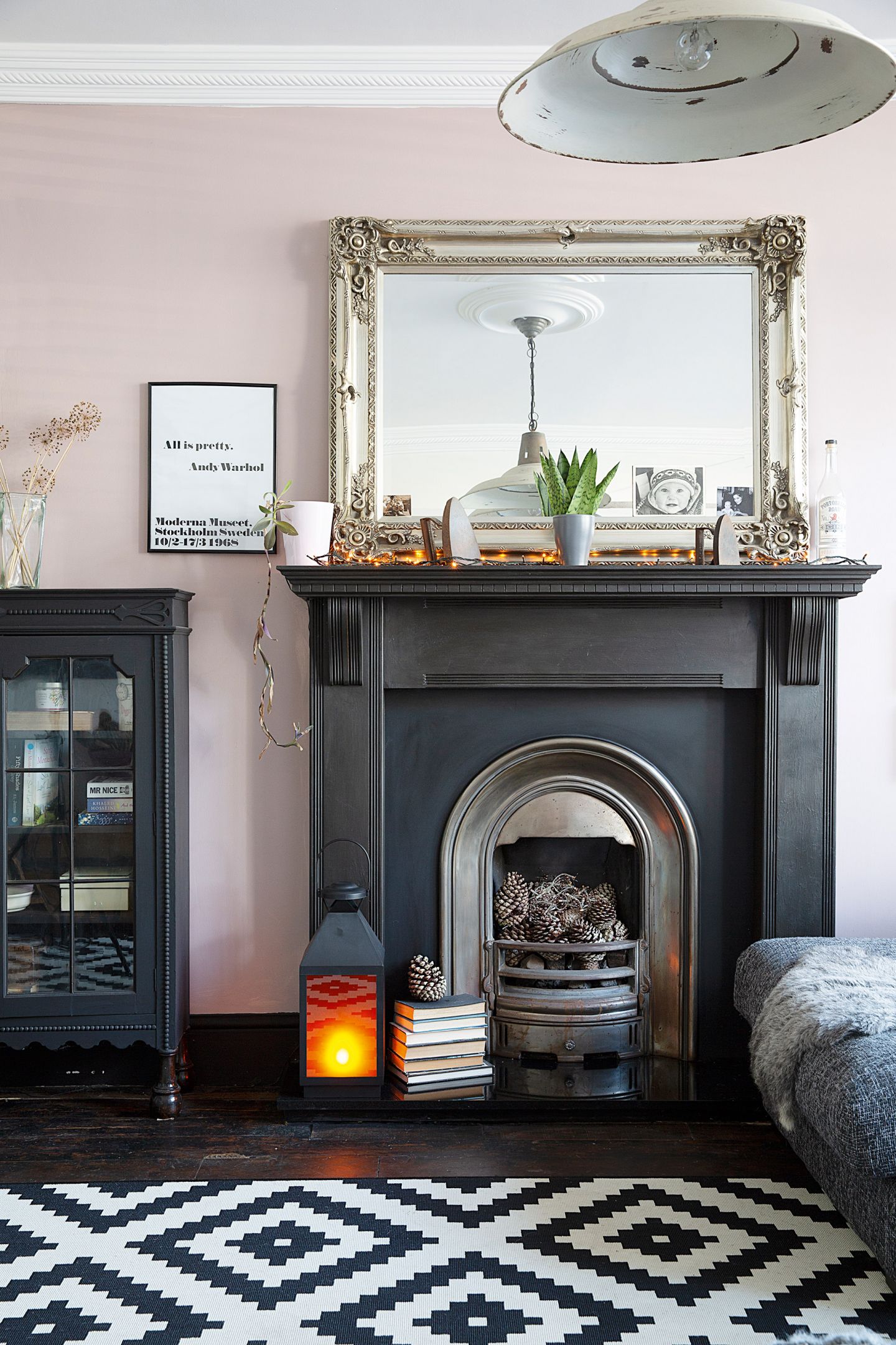 A pink living room paint color idea with fireplace and bold monochrome rug