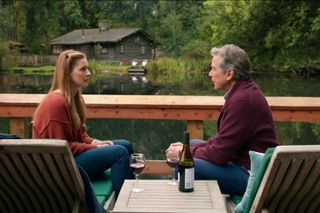 ALEXANDRA BRECKENRIDGE as MEL MONROE and TIM MATHESON as DOC MULLINS sat next to Mel's cabin in Virgin River