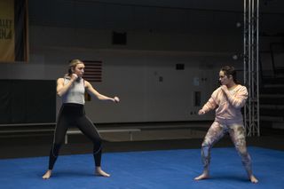 peyton list as tory and mary mouser as sam practicing karate on a mat in cobra kai season 6 part 3