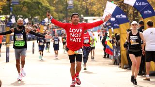 Runners cross the finish line during the 2021 TCS New York City Marathon in Central Park