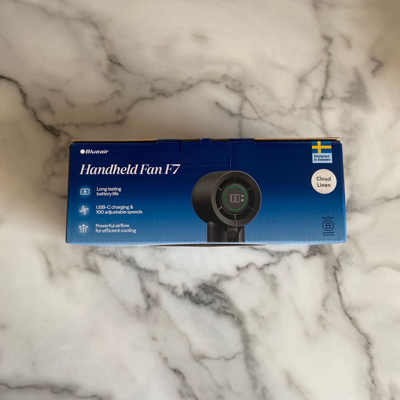 Packaging of the Blueair AlwaysCool Portable Handheld Fan on a marble look worktop