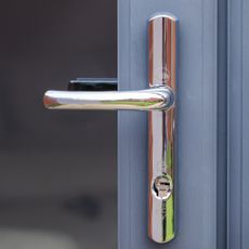 Silver door handle with hidden screws on blue door