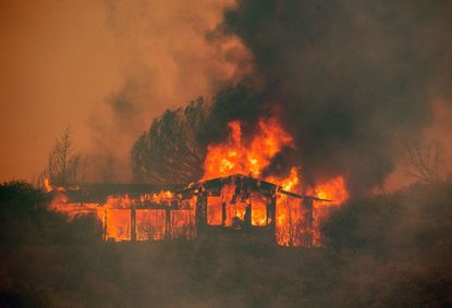 A house burns at the Mendocino Complex fire near Finley, California on July 30, 2018. 