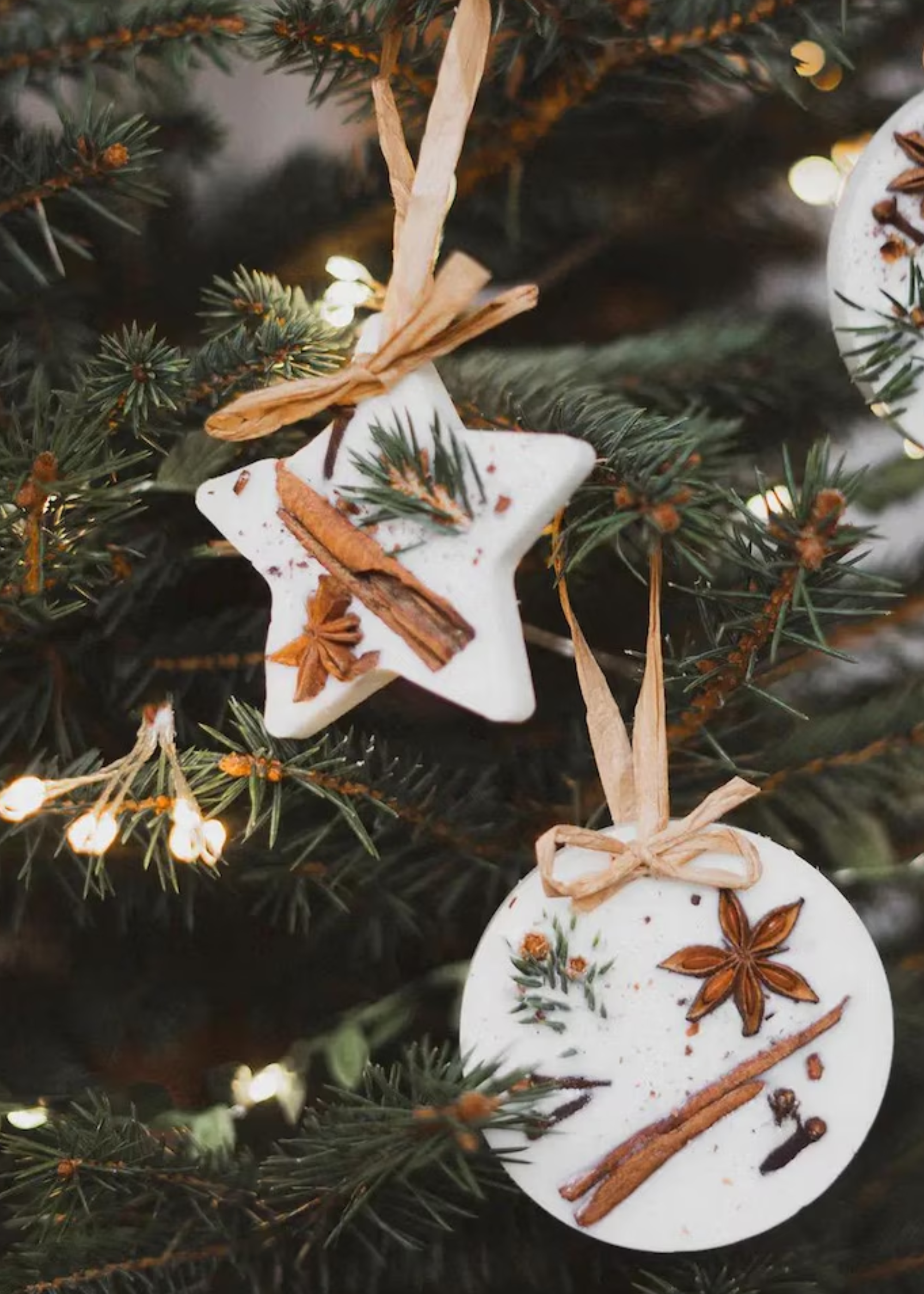 A close-up of a Christmas tree with wax tablet ornaments