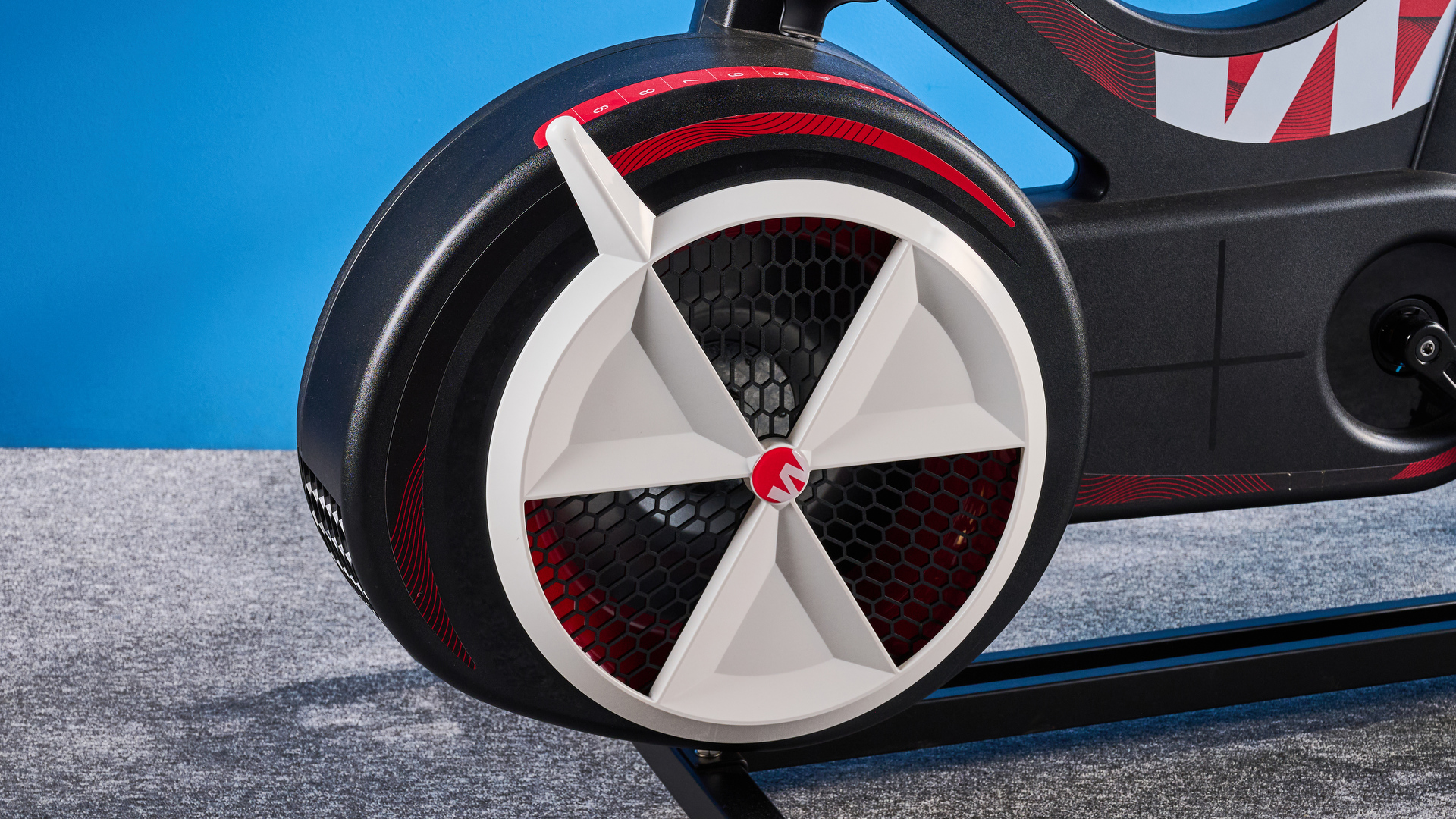 the wattbike air with a black and white front wheel, adjustable seat, and phone holder with app compatibility