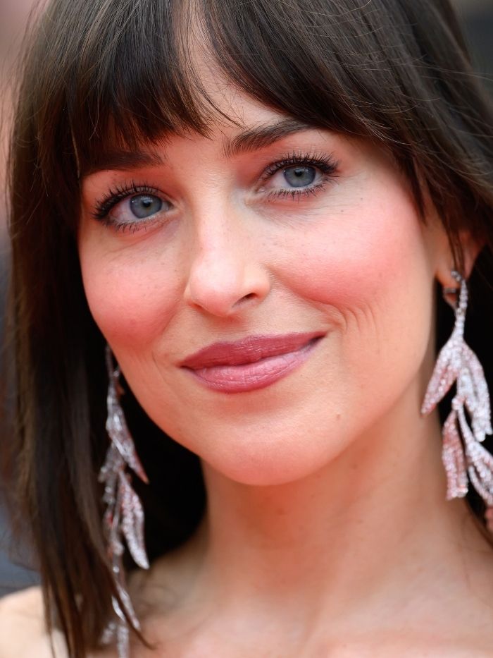 Dakota Johnson attends the "Highest 2 Lowest" red carpet at the 78th annual Cannes Film Festival at Palais des Festivals on May 19, 2025 in Cannes, France wearing a glowing makeup look