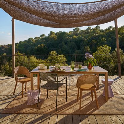 Wooden garden furniture with woven rug and an awning above
