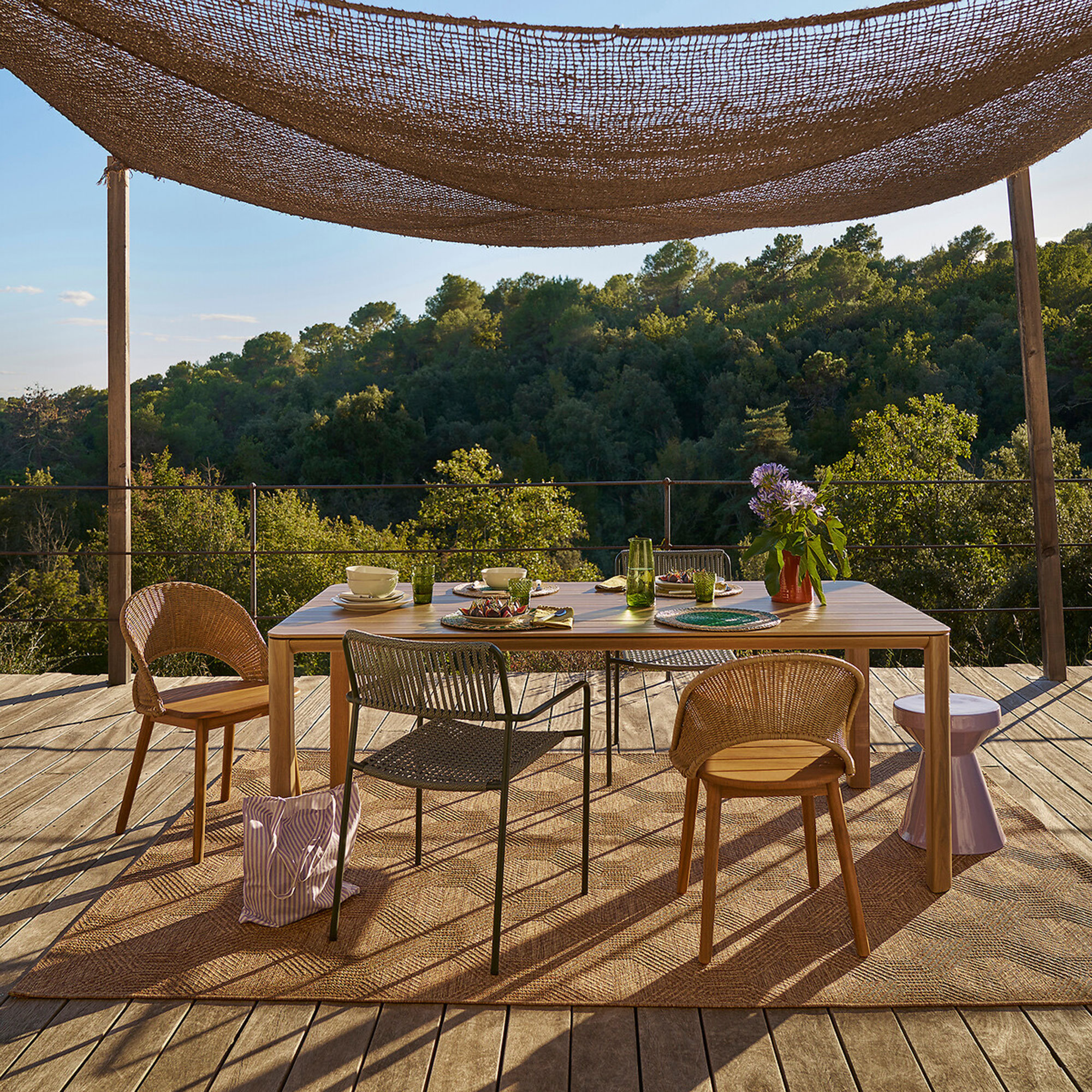 Wooden garden furniture with woven rug and an awning above