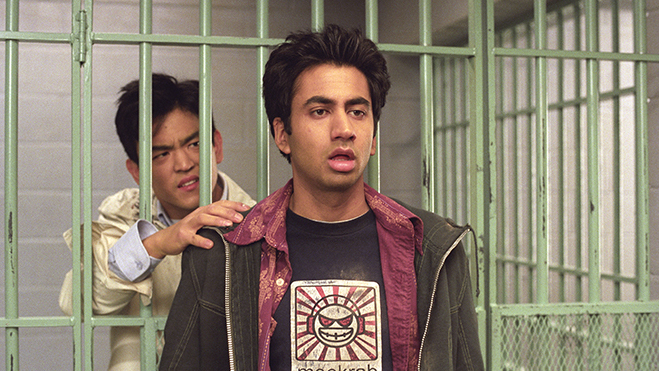 John Cho as Harold Lee (in a jail cell) stretching out to touch Kal Penn (as Kumar Patel) in Harold & Kumar Go to White Castle