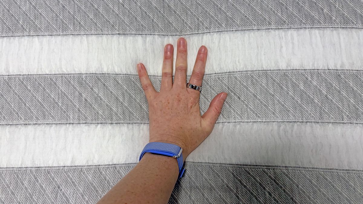 A close up of a hand pressing into the Leesa Original mattress
