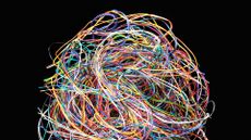 A photo of a large ball of multicolored wires, to represent technical debt, set against a black background.