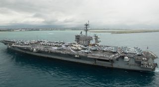 The aircraft carrier USS Theodore Roosevelt, which recently docked at Guam due to an onboard COVID-19 outbreak, is shown here in 2018 as it arrives in Pearl Harbor, Hawaii.