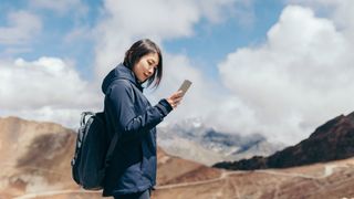 best weather apps for hiking: a mountaineer checking her weather app