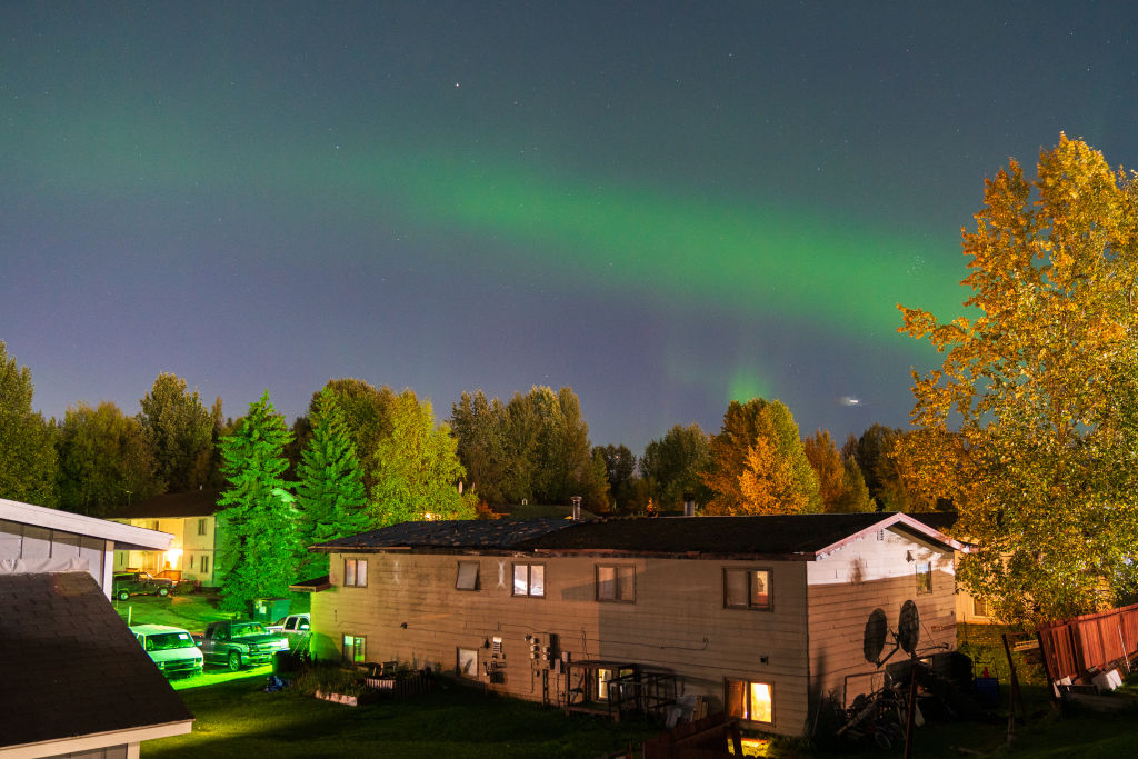 Cahaya utara di atas Alaska. Tirai cahaya hijau memenuhi langit.