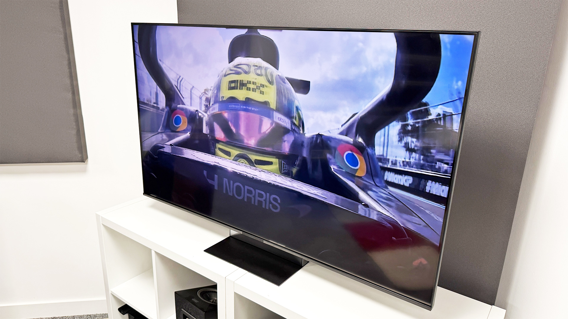 Sony Bravia 7 II RGB Mini LED TV on white shelving unit, on screen is F1 drive