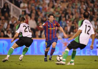 Lionel Messi runs past two Racing Santander defenders before scoring for Barcelona at El Sardinero in September 2009.