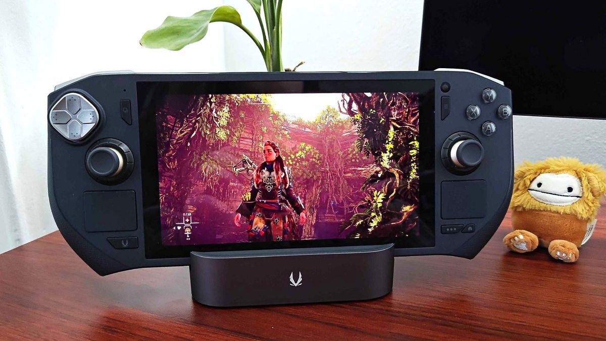 Zotac Zone gaming handheld sitting on docking station with Horizon: Forbidden West gameplay on screen