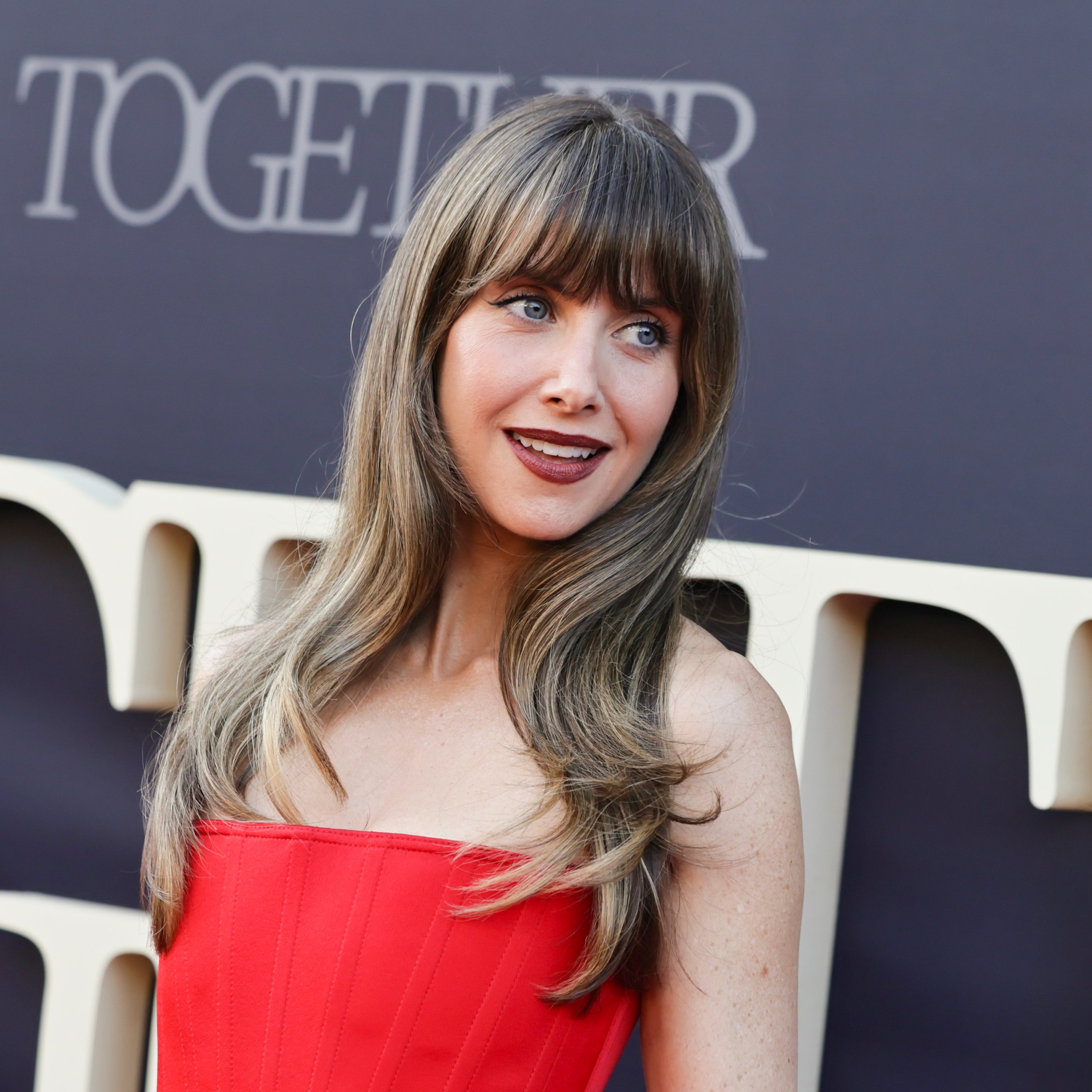 Alison Brie posing with her hair highlighted.