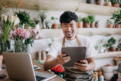 Man looking at an iPad or tablet computer in a flower shop