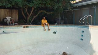 Swamp Dogg sits by the empty pool