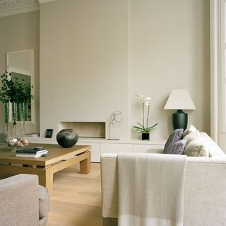 living room with white wall white sofa square table and wooden flooring