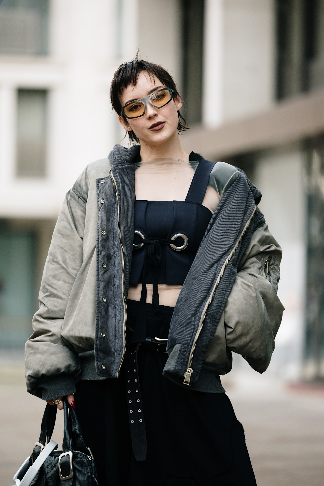 A woman with a cropped haircut and statement brown lipstick