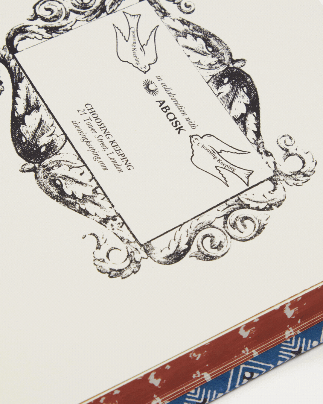A rotating gif showcasing a handmade notebook with a patterned cover in blue, red, yellow, and white.