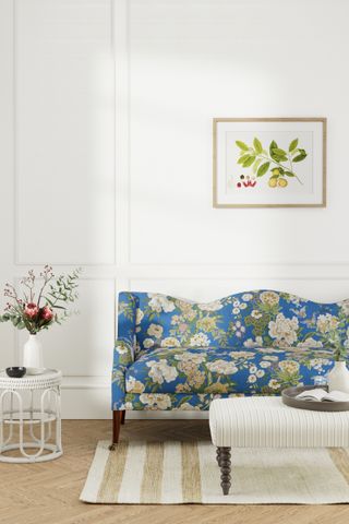 simple white sitting room with blue floral sofa