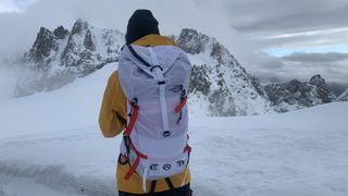 Hiker wearing a white backpack on a glacier