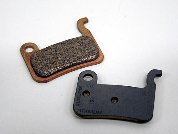 Shimano increases performance and saves some titanium from the recycling bin by using center cutouts from its titanium cassette cogs as backing material for the new XTR metallic disc brake pads.