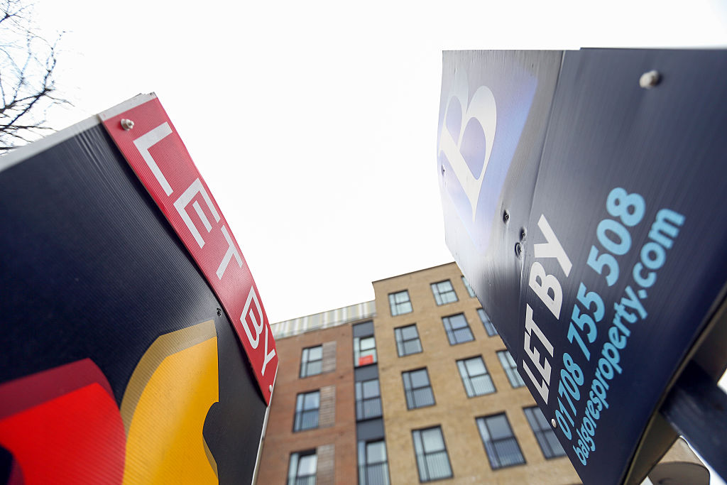 Estate agents' 'Let By' signs stand outside residential properties in Romford, London