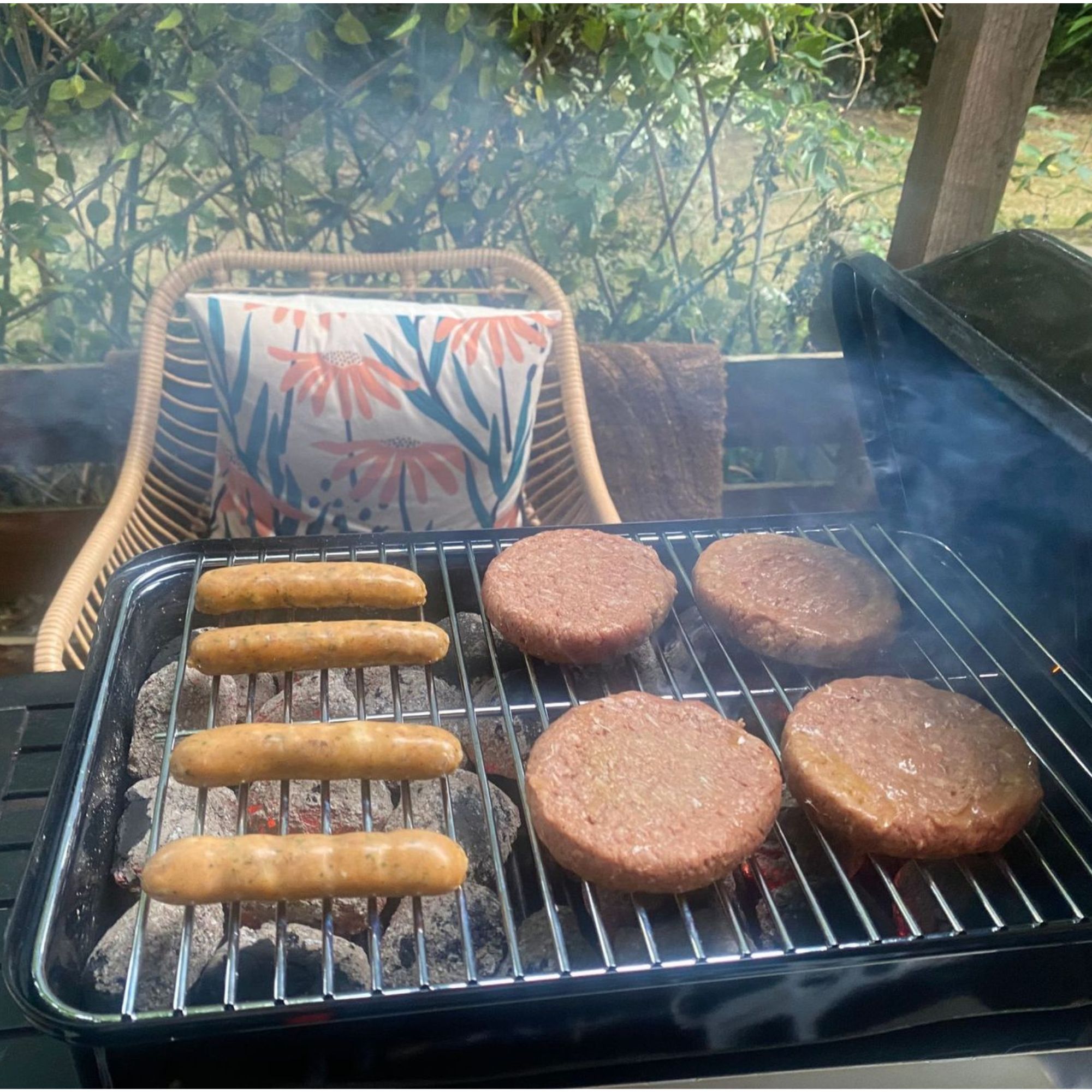Weber BBQ cooking burgers and sausages